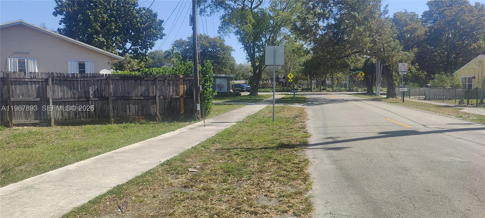 5825 Fillmore Street Hollywood, FL 33021 - Photo 4 of 6 a view of a yard with a house and large trees with wooden fence