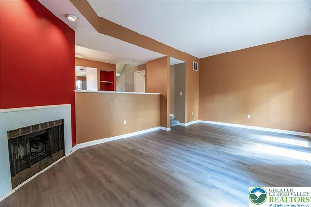 a view of a livingroom with wooden floor and a fireplace