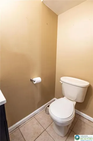 a white toilet sitting next to a white wall