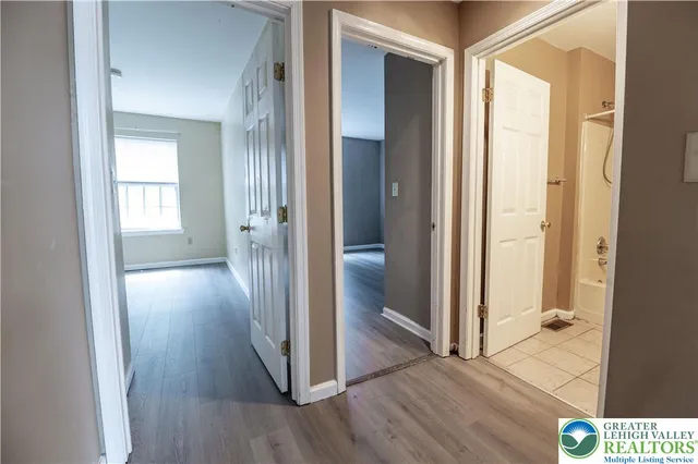 a view of a hallway with wooden floor and closet area