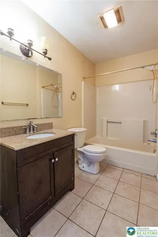 a spacious bathroom with a double vanity sink toilet and a mirror