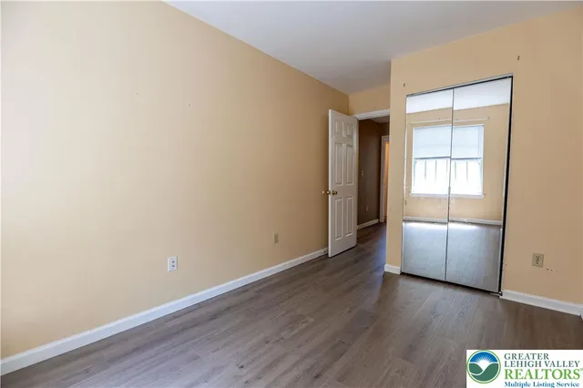 an empty room with wooden floor and cabinet