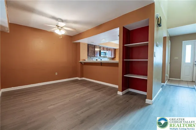 an empty room with wooden floor wooden floor and windows