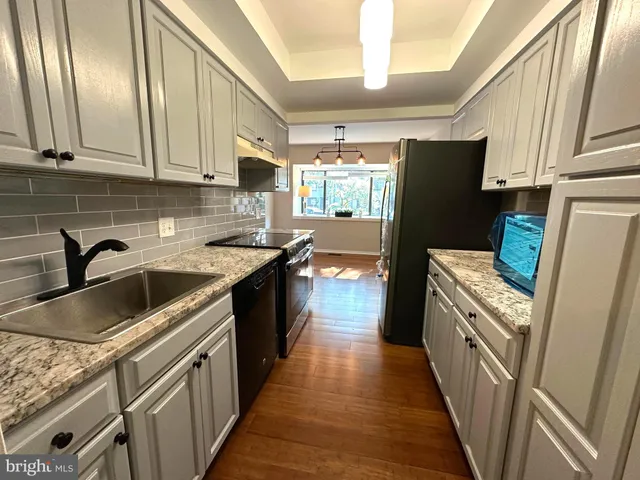 a kitchen with a sink a refrigerator and cabinets
