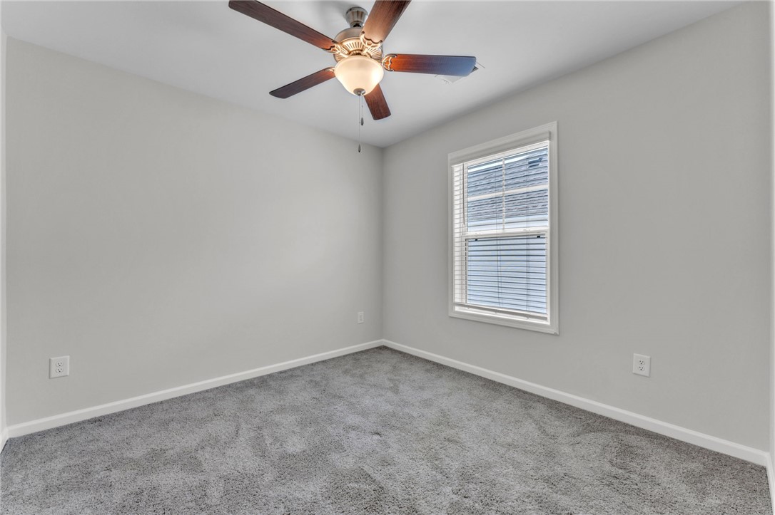 208 Samuel Street Pendleton, SC 29670 - Photo 20 of 32 A well-lit bedroom features plush carpeting and a modern ceiling fan for comfort.