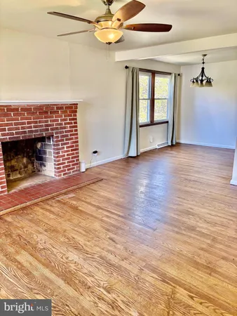 an empty room with windows and fireplace