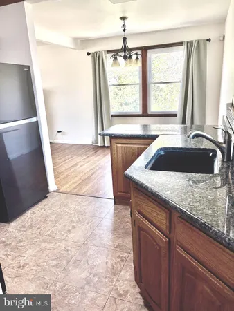 a kitchen with a sink a granite counter top and a window
