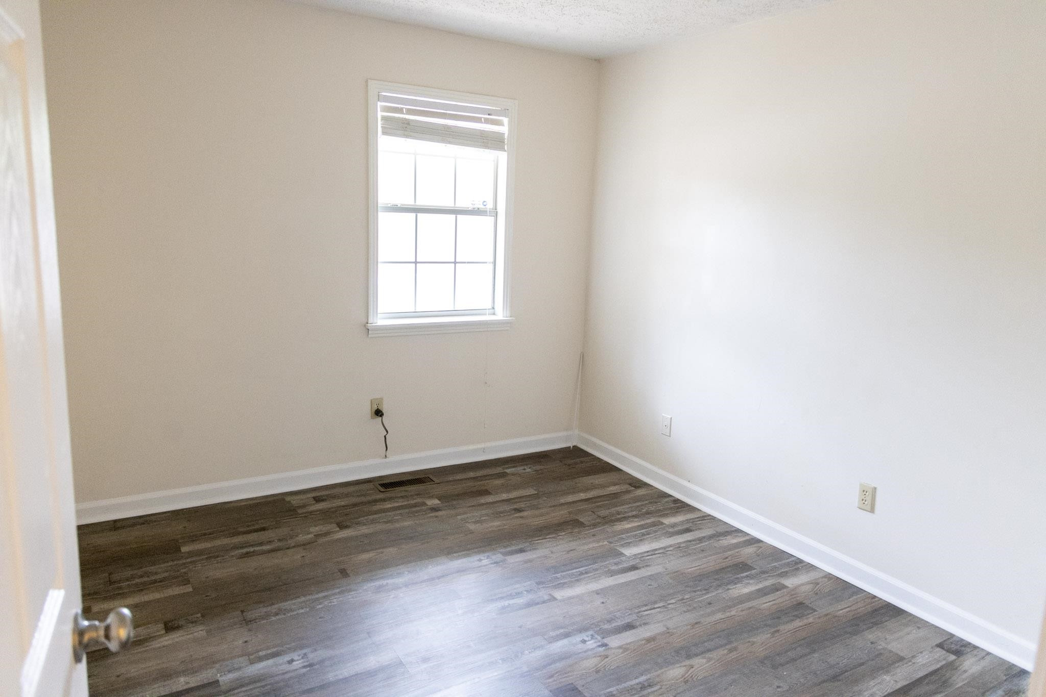 2829 Riverside Drive Jackson, TN 38301 - Photo 6 of 20 an empty room with wooden floor and window