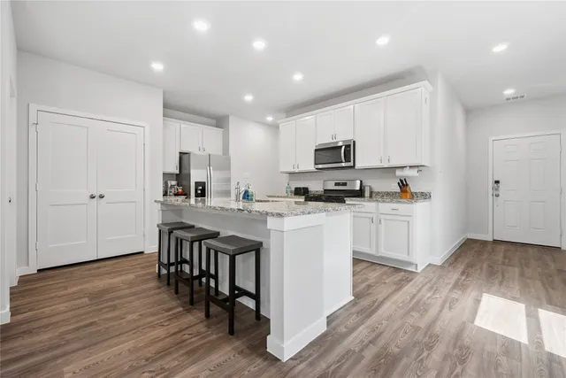 a kitchen with white cabinets and stainless steel appliances