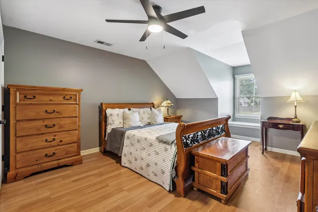 a bedroom with a bed and wooden floor