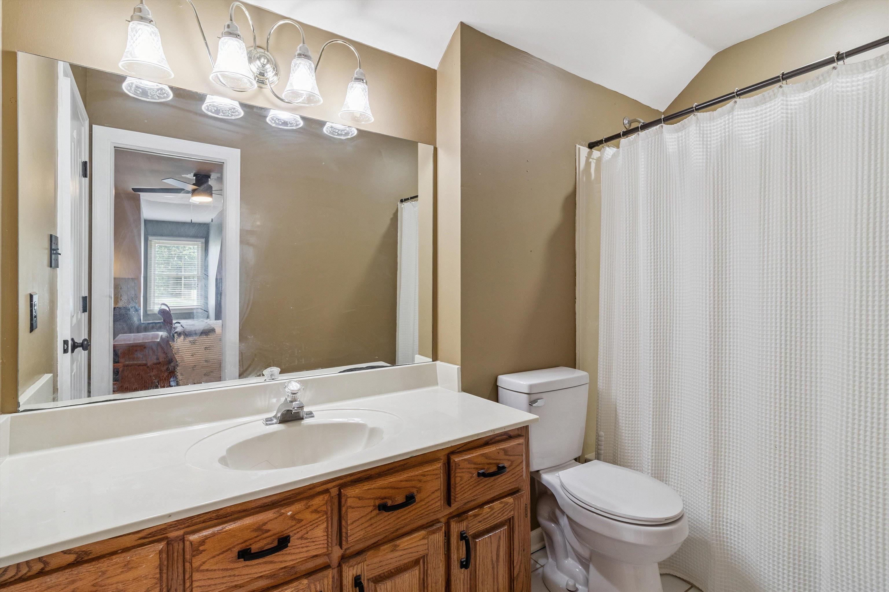 683 Fletcher Road Collierville, TN 38017 - Photo 24 of 30 a bathroom with a granite countertop sink toilet a mirror and a shower