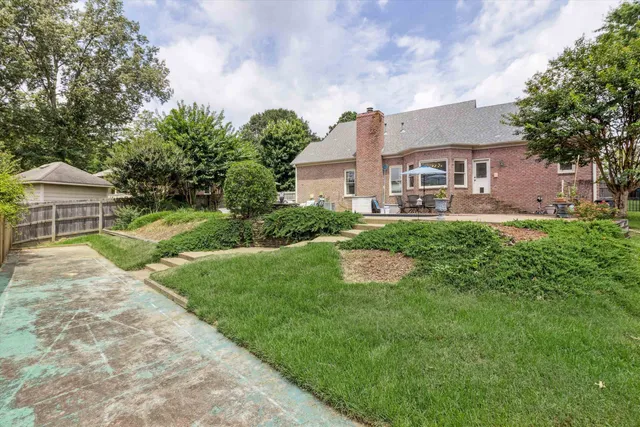 a front view of a house with a yard and trees
