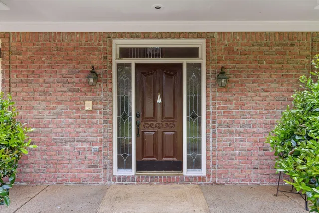 a front view of a building with a garden and entryway