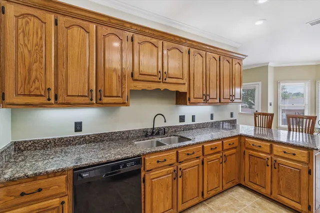 a kitchen with stainless steel appliances granite countertop a sink dishwasher cabinets and granite countertops with wooden floor
