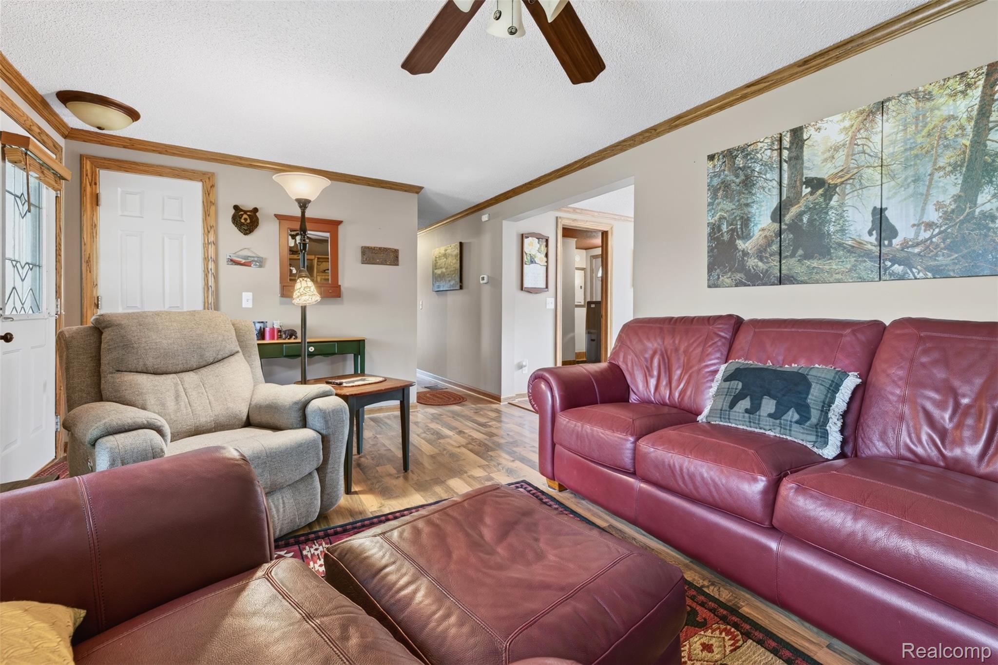 5977 Anglers Road Ortonville, MI 48462 - Photo 6 of 63 Spacious living area featuring wood-finish flooring, a ceiling fan, and decorative wood trim