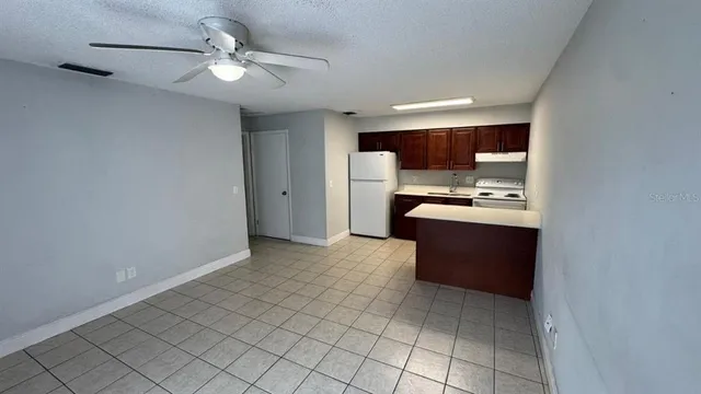 a view of kitchen with refrigerator and cabinets