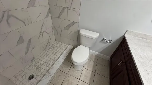a bathroom with a toilet and a shower