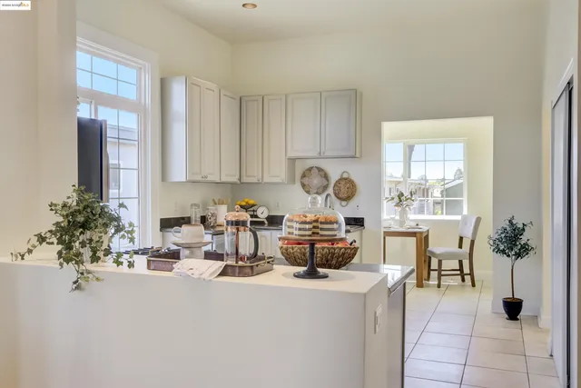 a living room with furniture a large window and potted plants
