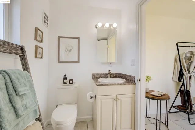 a bathroom with a granite countertop toilet a sink and a mirror