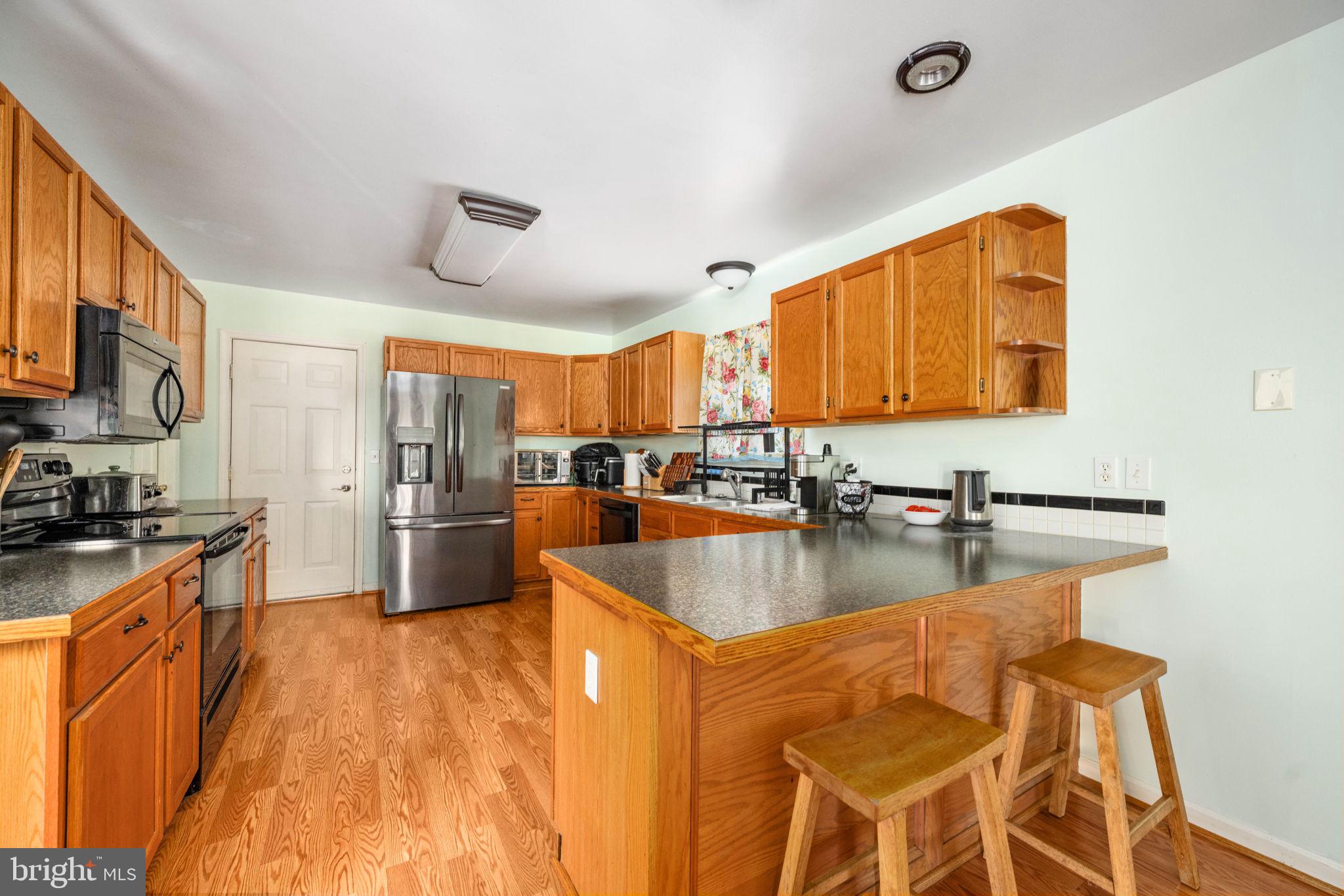 203 Fairfax Lane Locust Grove, VA 22508 - Photo 26 of 54 a kitchen with stainless steel appliances granite countertop a sink a stove and a wooden floors