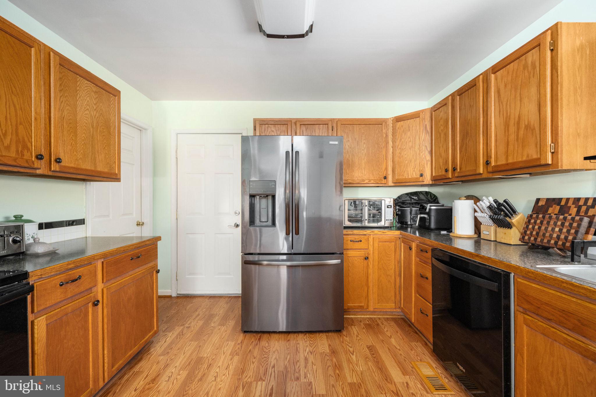 203 Fairfax Lane Locust Grove, VA 22508 - Photo 27 of 54 a kitchen with granite countertop wooden floors stainless steel appliances and cabinets