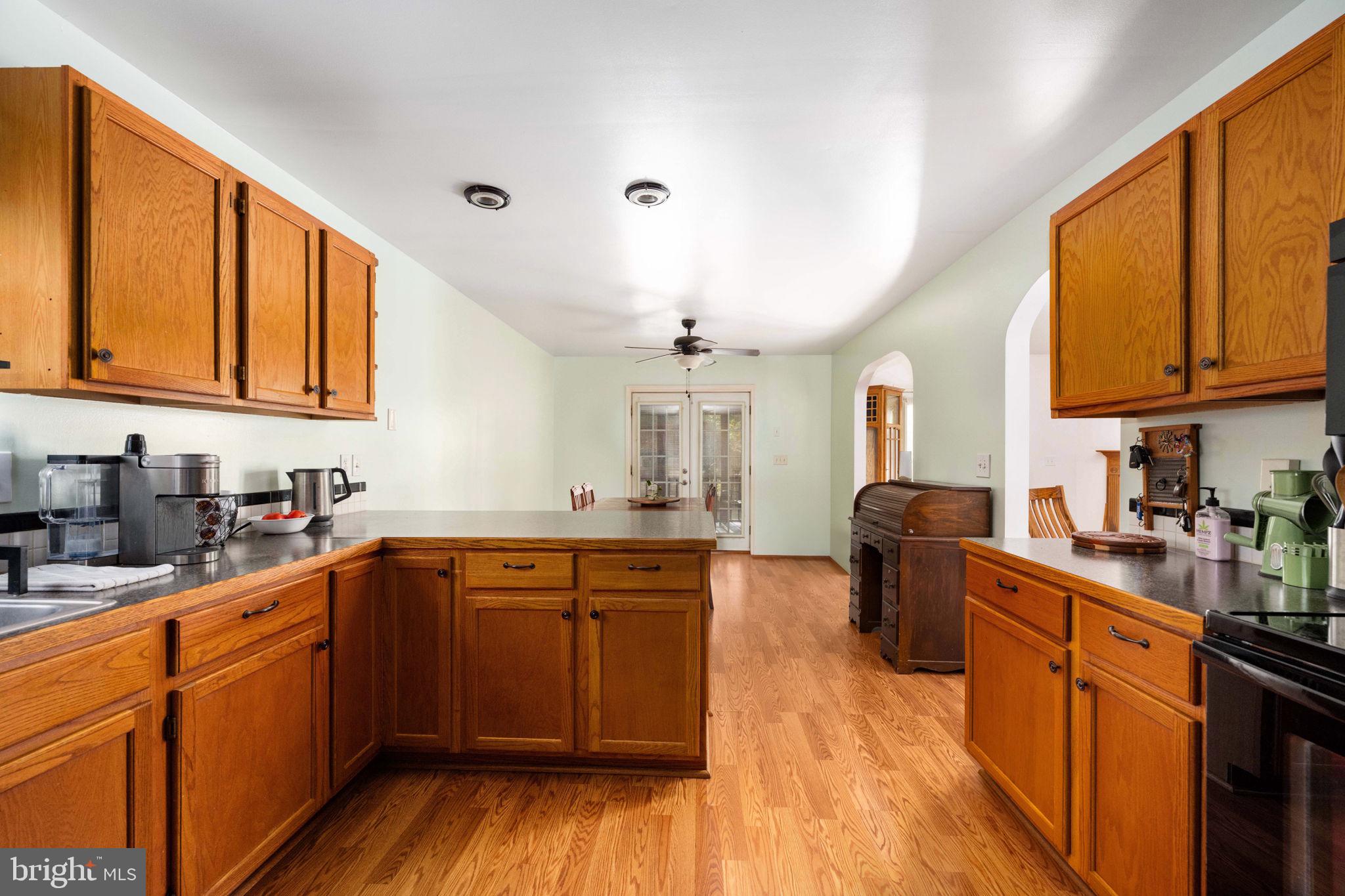 203 Fairfax Lane Locust Grove, VA 22508 - Photo 29 of 54 a kitchen with stainless steel appliances granite countertop wooden cabinets a sink dishwasher a stove and a refrigerator with wooden floor