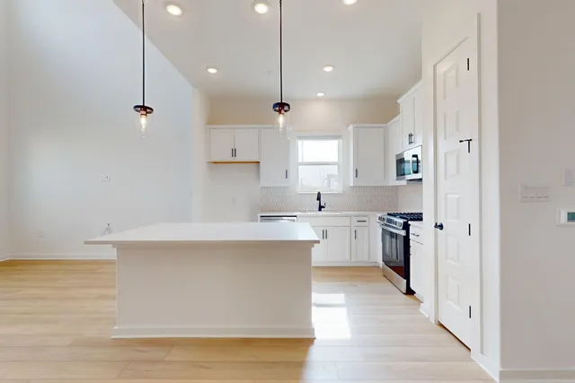 a kitchen with white cabinets and white appliances