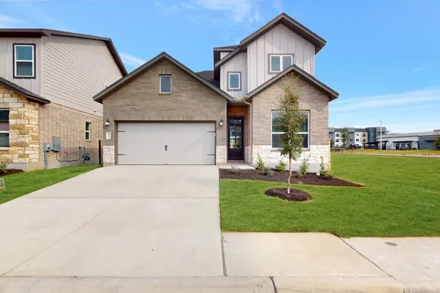 a front view of a house with a yard and garage