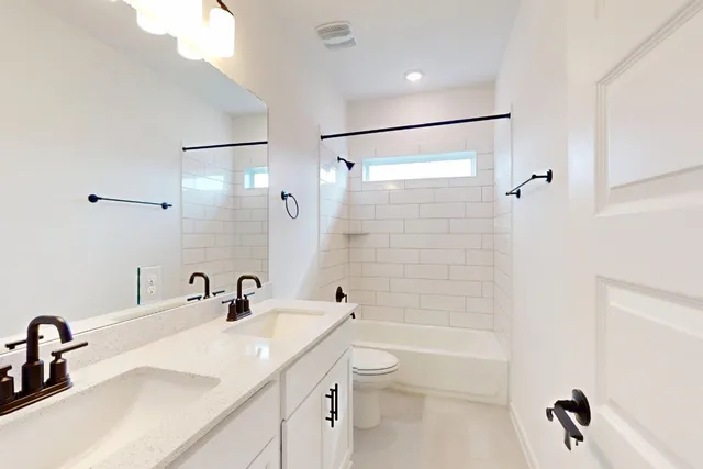 a bathroom with a tub shower sink vanity and a mirror