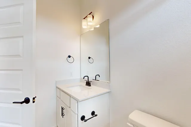 a bathroom with a sink a toilet and mirror