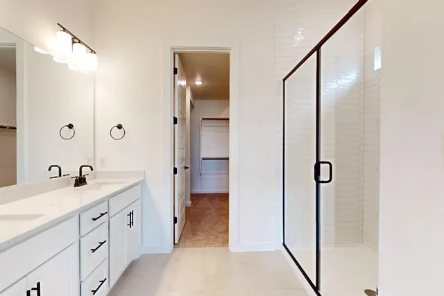 a bathroom with a double vanity sink a mirror and shower