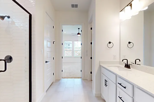 a bathroom with a double vanity sink a mirror and shower