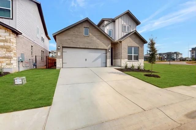 a front view of a house with a yard and trees