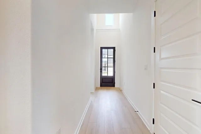a view of a hallway with wooden floor and staircase