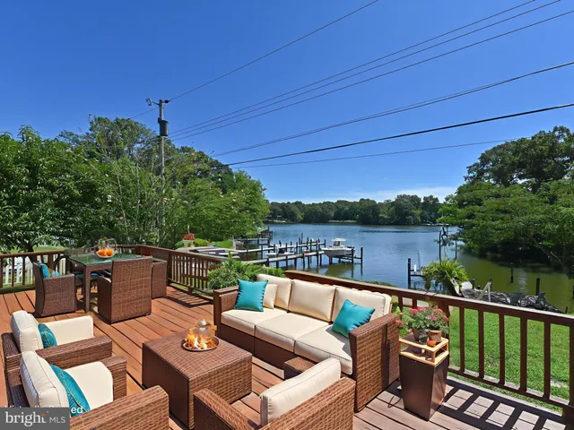 a view of a patio with couches chairs under an umbrella