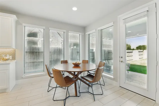 a dining room with granite countertop kitchen island stainless steel appliances a table and chairs