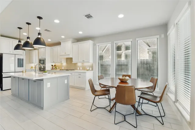 a kitchen with stainless steel appliances a stove a sink a center island and cabinets