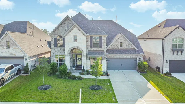 a view of a white house next to a yard with big trees