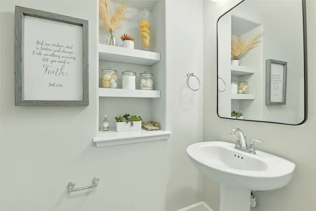 a hallway with painting and potted plants