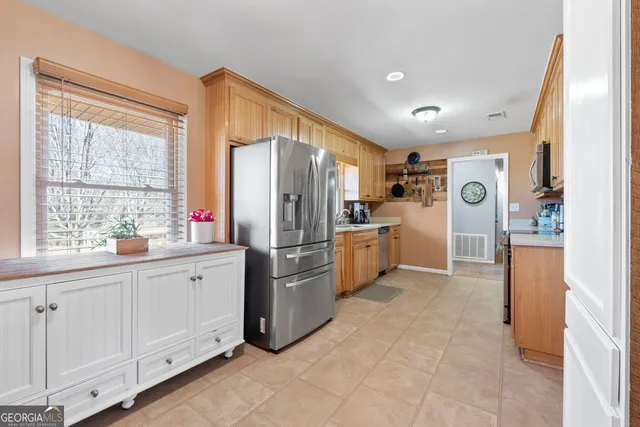 a kitchen with stainless steel appliances granite countertop a stove a sink and a refrigerator