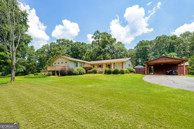 a view of a house with swimming pool and a yard