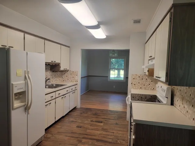 a kitchen with stainless steel appliances granite countertop a refrigerator a stove and a wooden cabinets