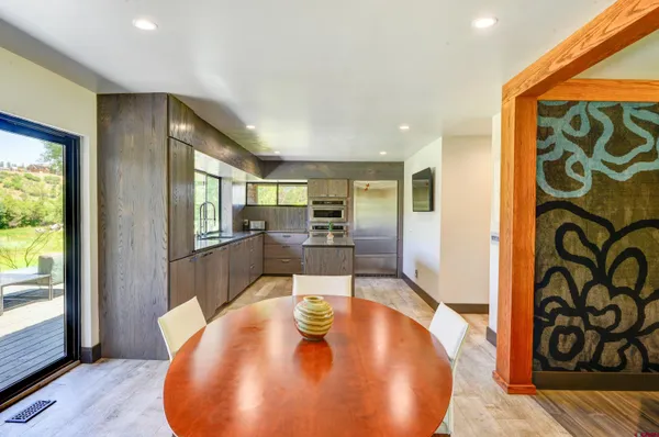 a kitchen with stainless steel appliances granite countertop a refrigerator a sink a stove a washer dryer and a large window