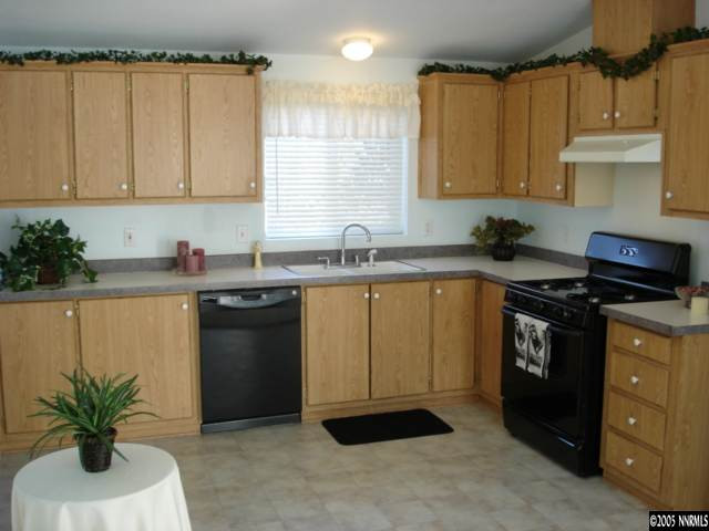 15505 Toll Road Reno, NV 89521 - Photo 3 of 9 a kitchen with granite countertop a sink a stove and cabinets