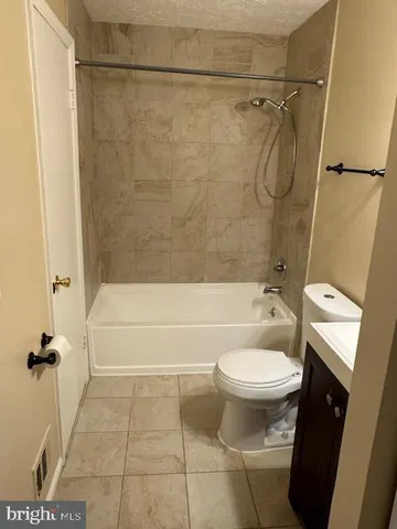 a bathroom with a white bath tub a toilet and a shower