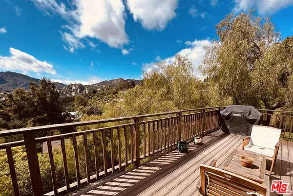 a view of balcony with wooden floor and fence
