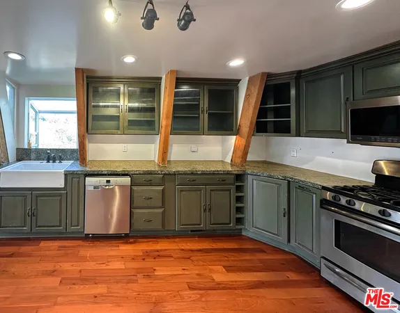 a kitchen with stainless steel appliances granite countertop a stove a sink and a microwave