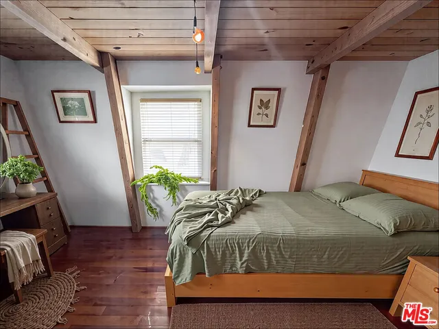 a bedroom with a bed and a potted plant