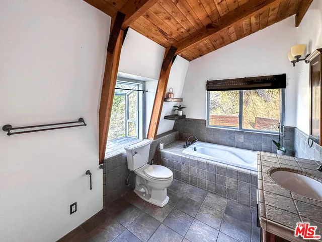 a bathroom with a granite countertop sink toilet and tub