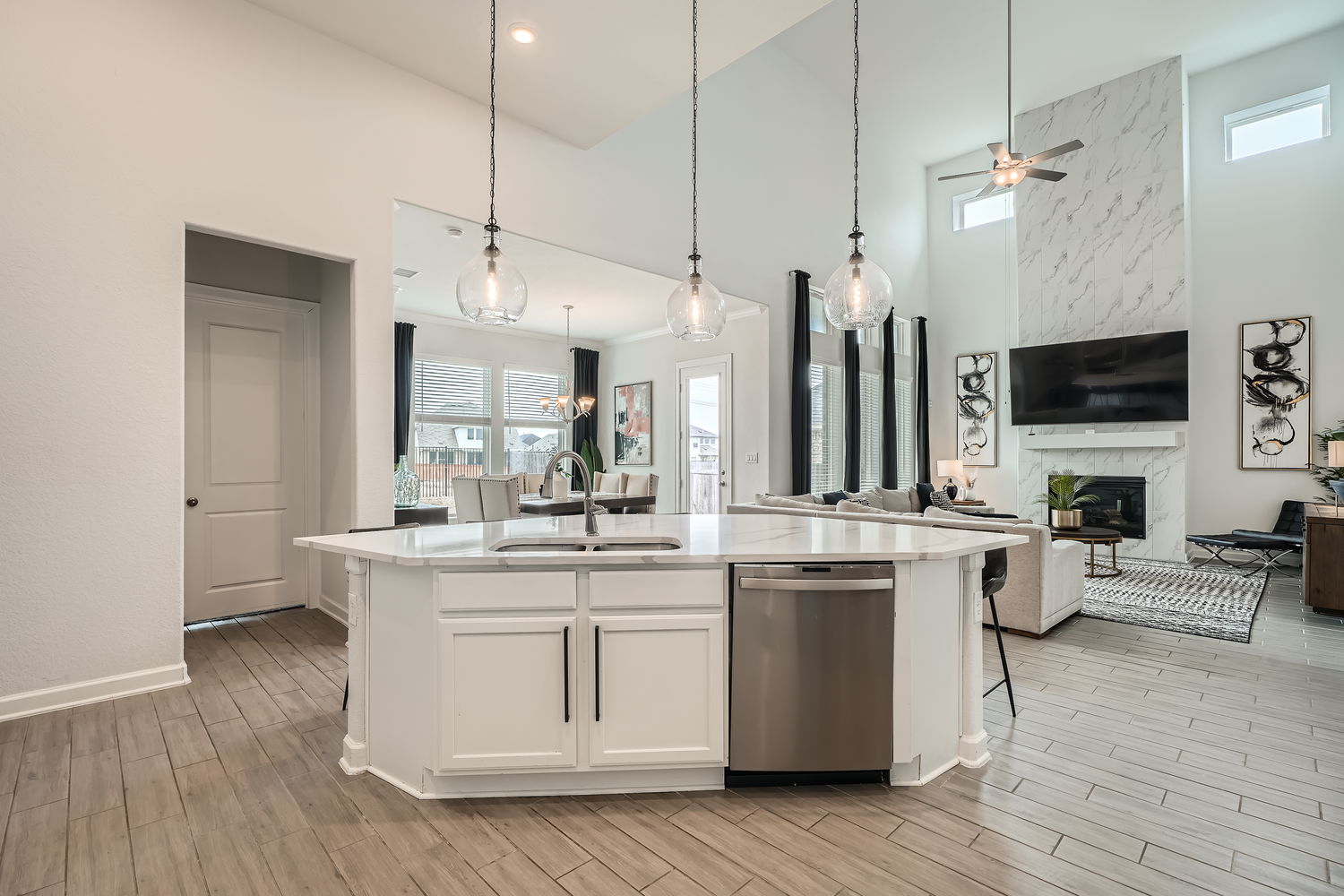 582 Wild Pecan Loop Buda, TX 78610 - Photo 28 of 28 Kitchen featuring open floor plan, dishwasher, a high ceiling, white cabinetry, and wood tiled floors